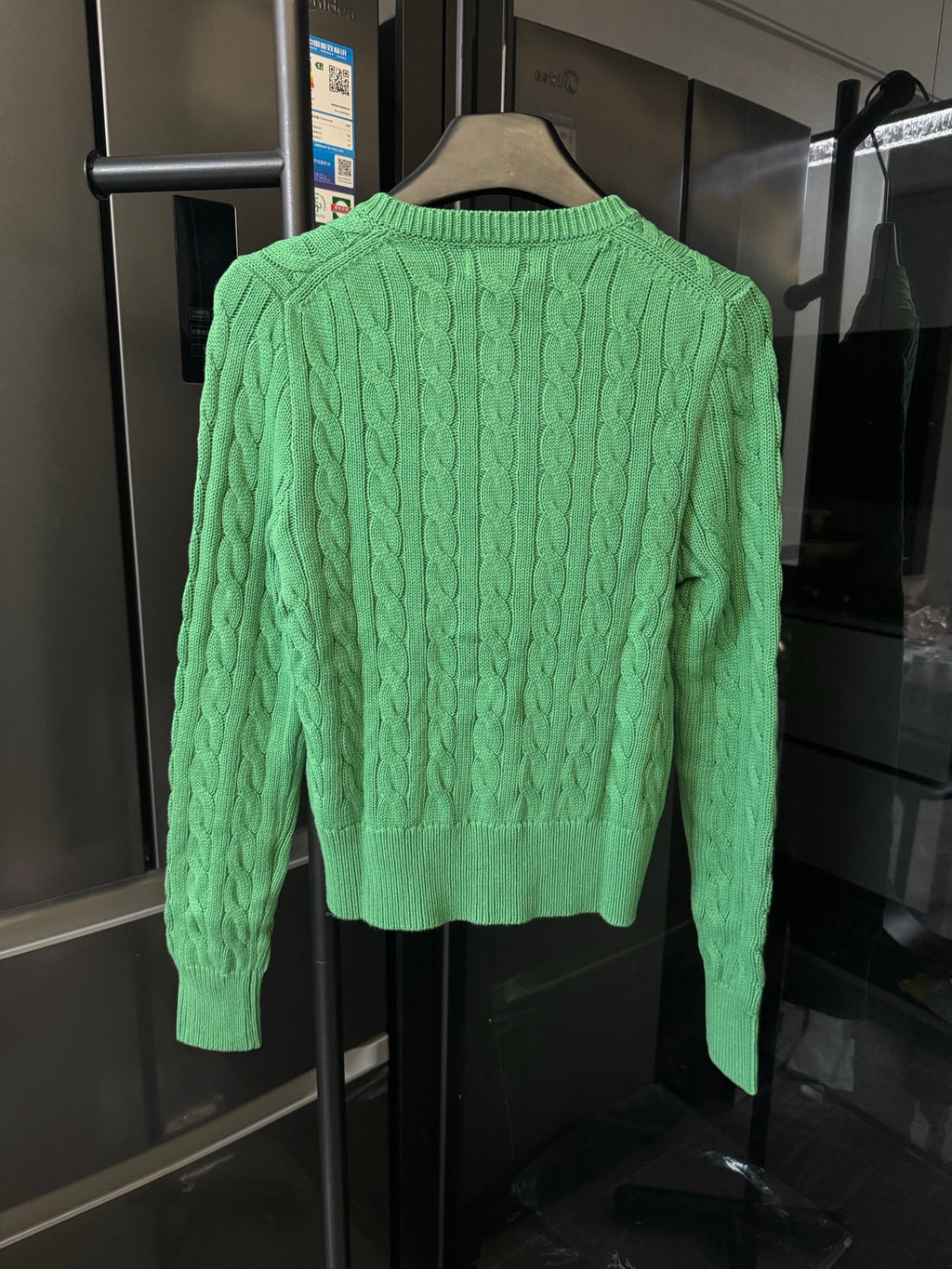 Green cable-knit cardigan, button front and textured knit pattern (back view)