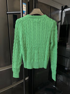 Green cable-knit cardigan, button front and textured knit pattern (back view)