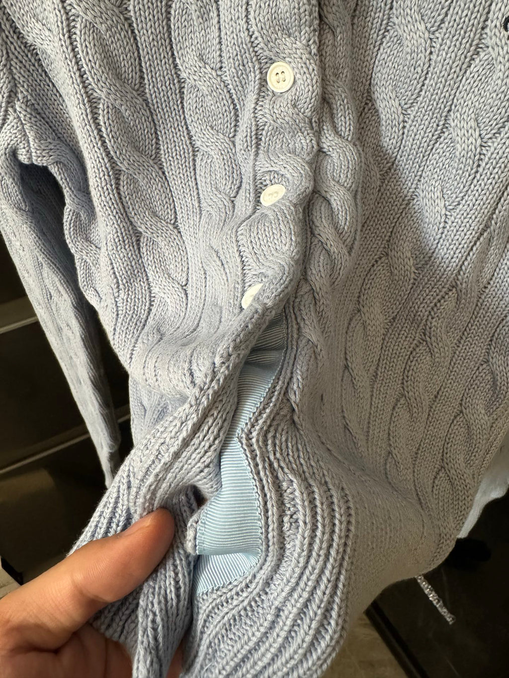 Ralph Lauren cable-knit cardigan detail, cream knit with white buttons.