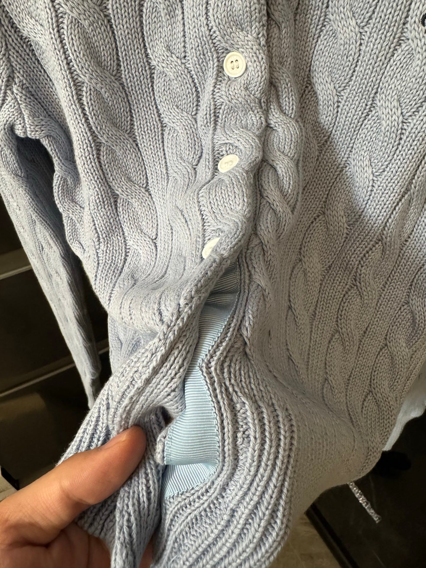 Ralph Lauren cable-knit cardigan detail, cream knit with white buttons.