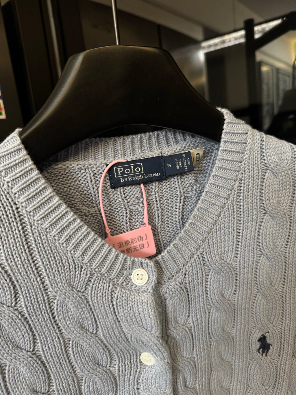 Ralph Lauren cable-knit cardigan neckline, cream knit with button placket and Polo logo.