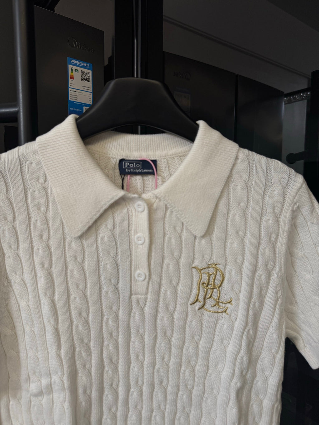 Ivory cable-knit polo shirt with ribbed collar, button placket, and gold logo
