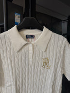 Ivory cable-knit polo shirt with ribbed collar, button placket, and gold logo