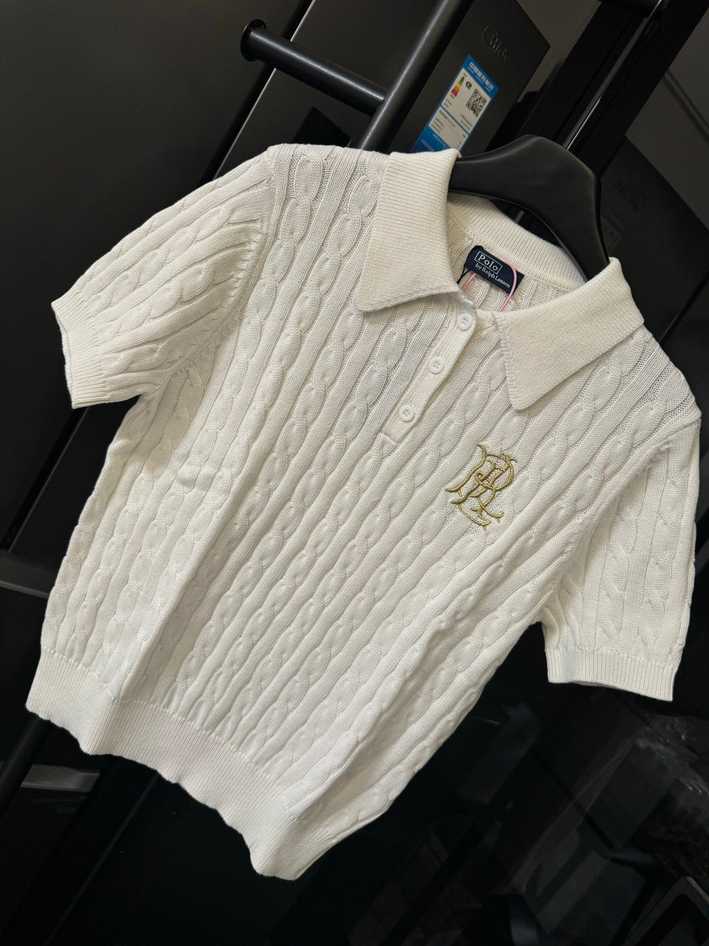 Ivory cable-knit polo shirt with embroidered gold logo on chest and button placket