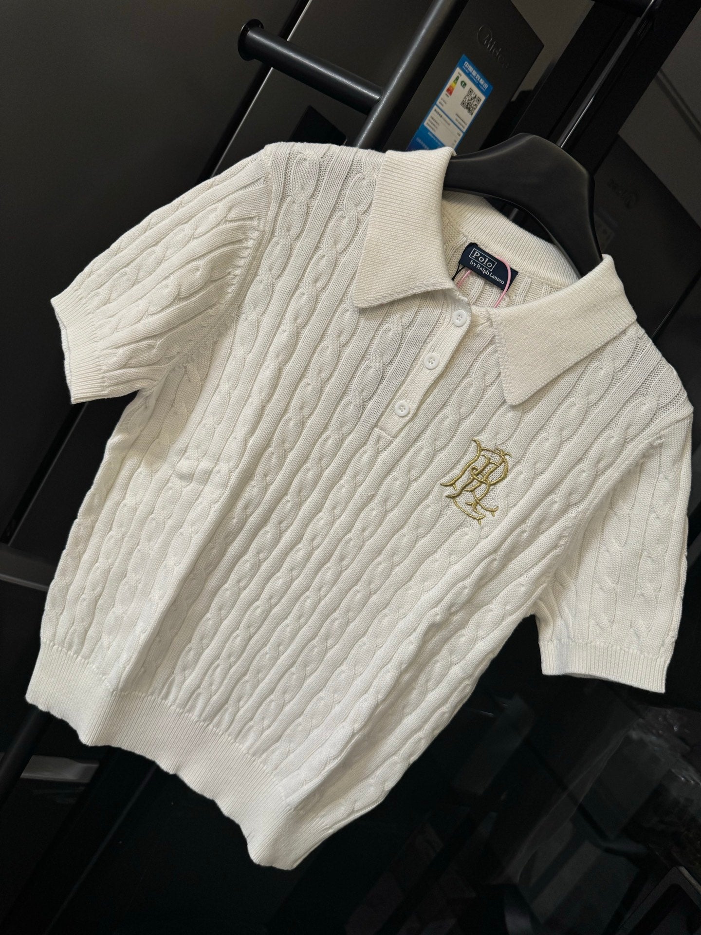 Ivory cable-knit polo shirt with embroidered gold logo on chest and button placket