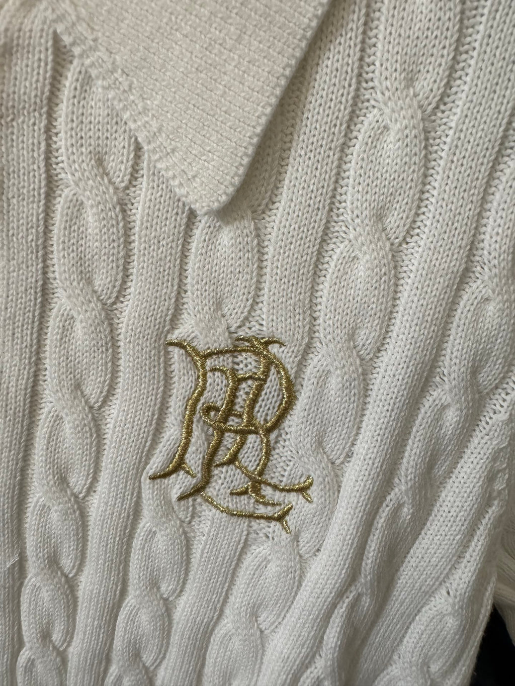 Ivory cable-knit polo shirt with embroidered gold logo on chest
