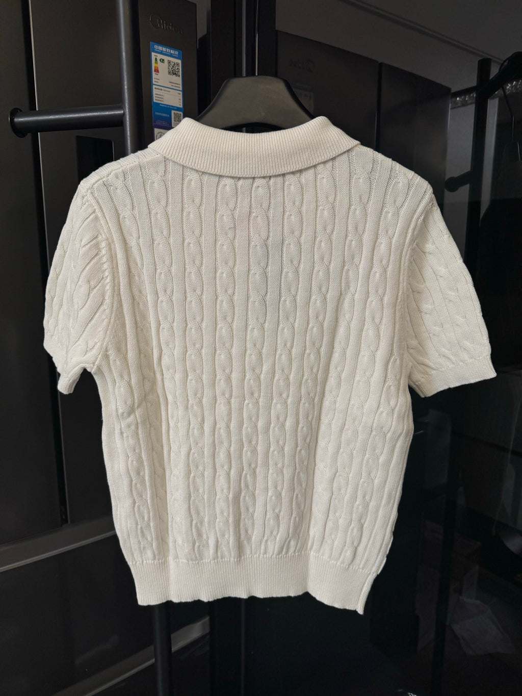 Ivory cable-knit polo shirt back view with ribbed collar and short sleeves