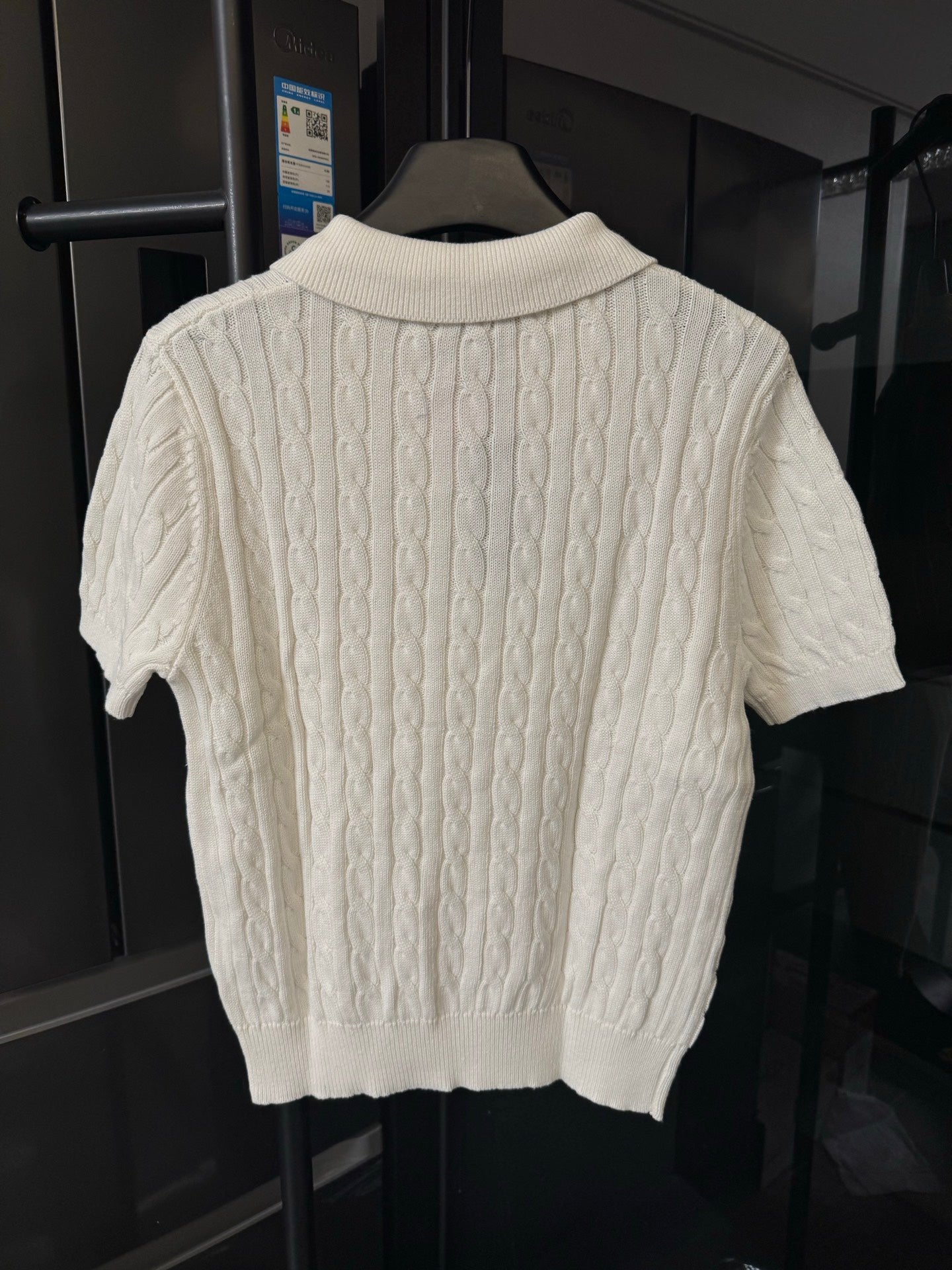 Ivory cable-knit polo shirt back view with ribbed collar and short sleeves