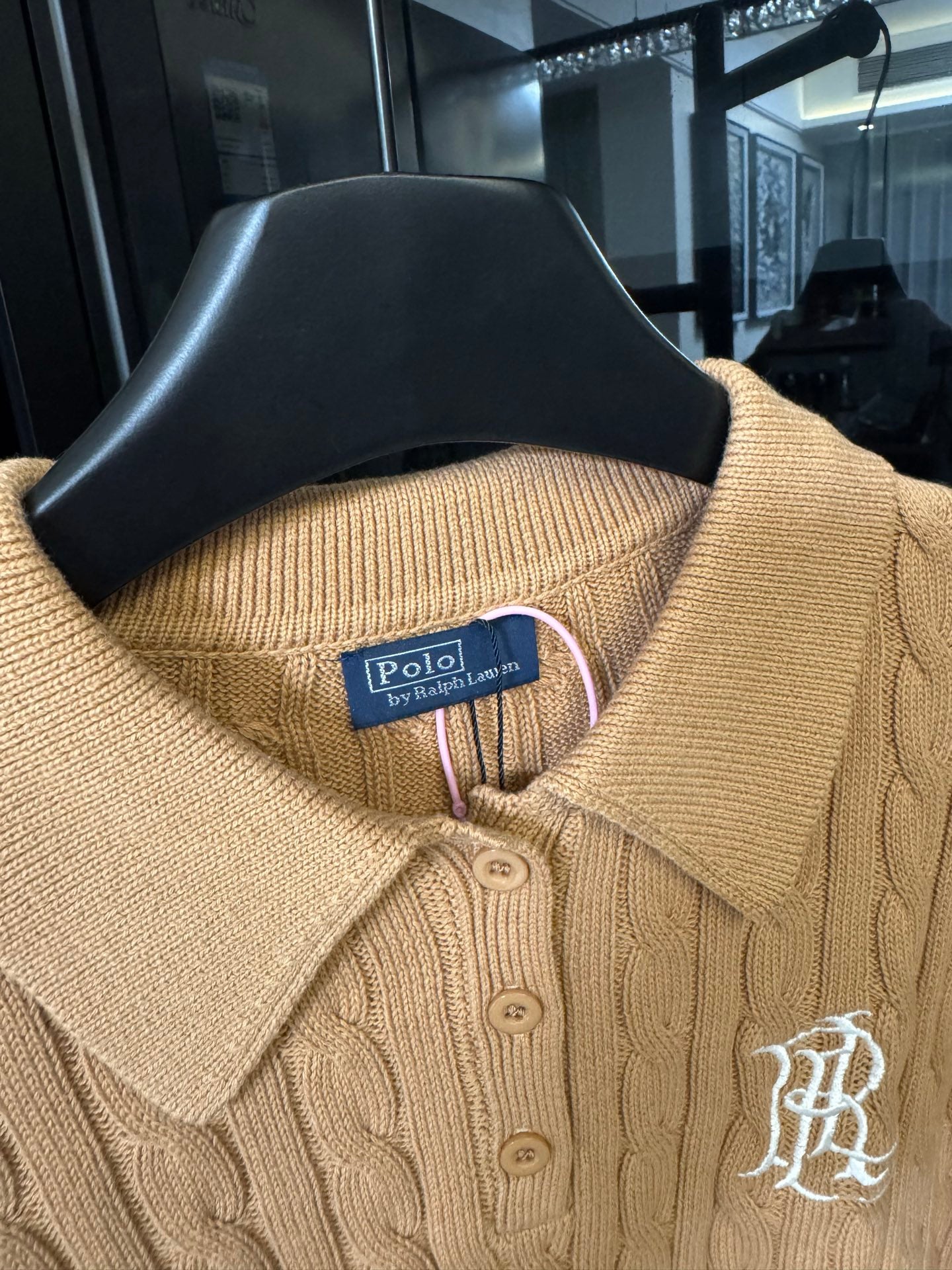 Ralph Lauren cable-knit polo shirt in beige, close-up of ribbed collar and button placket.