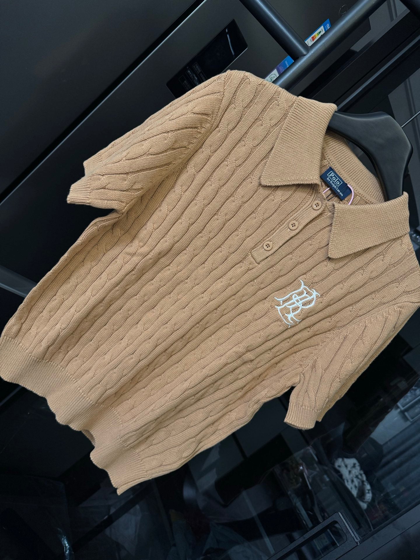 Ralph Lauren cable-knit polo shirt in beige, front three-quarter view with chest logo.