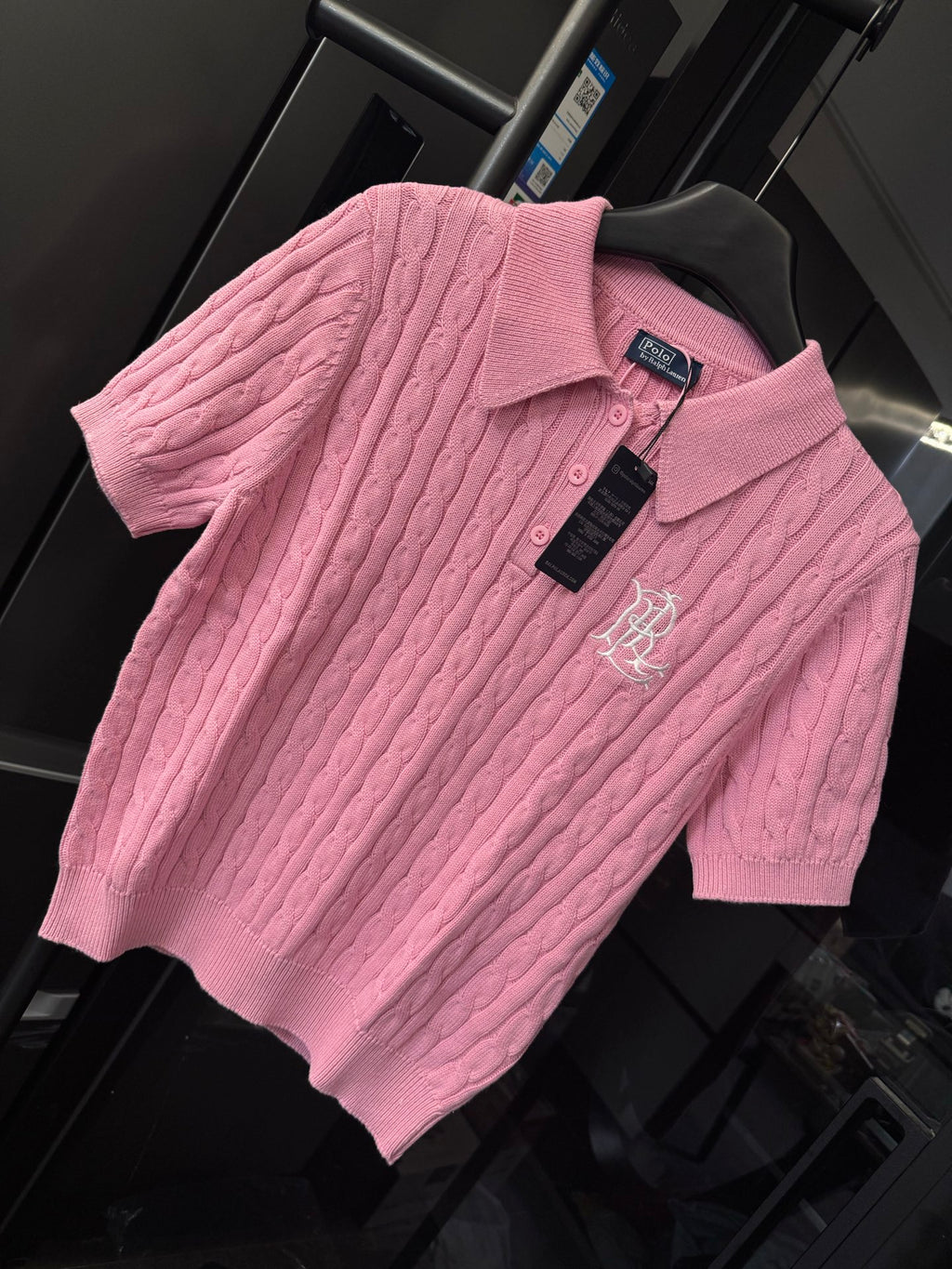 Pink cable-knit polo shirt with RL emblem, button placket, and hanging tag