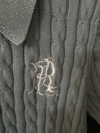 Embroidered logo on gray cable-knit polo sweater front