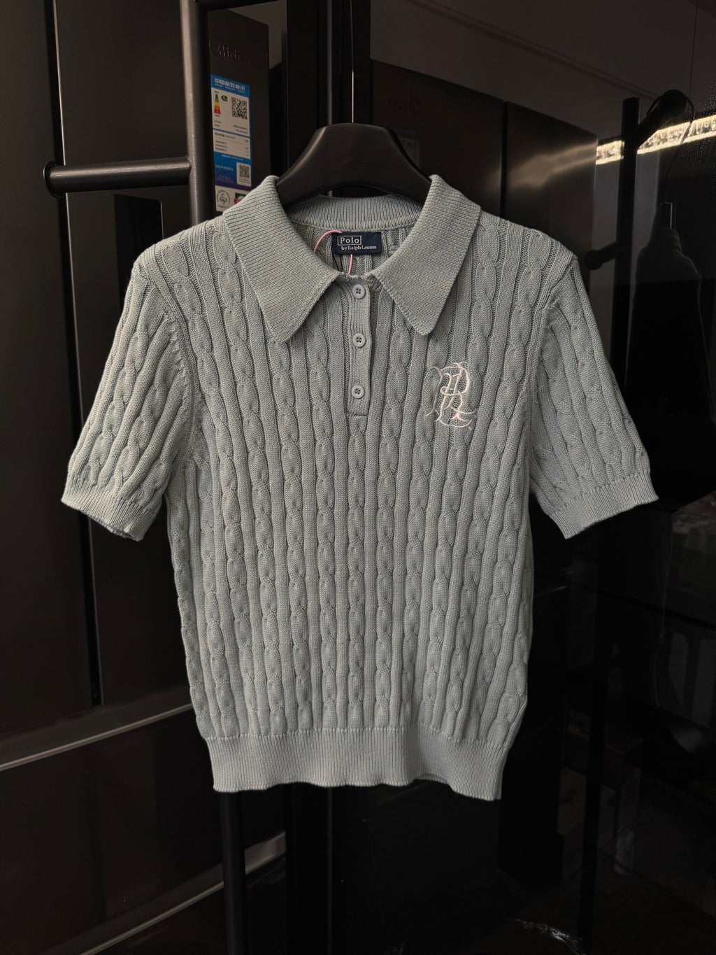 Gray cable-knit polo sweater with button placket and embroidered logo on chest