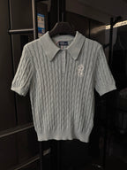 Gray cable-knit polo sweater with button placket and embroidered logo on chest