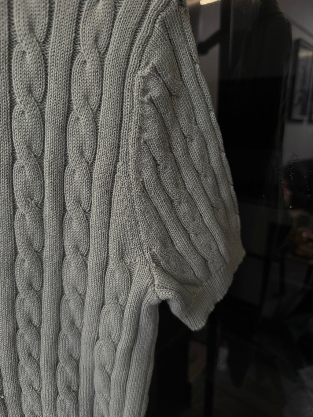 Gray cable-knit polo sweater side view with textured cable pattern