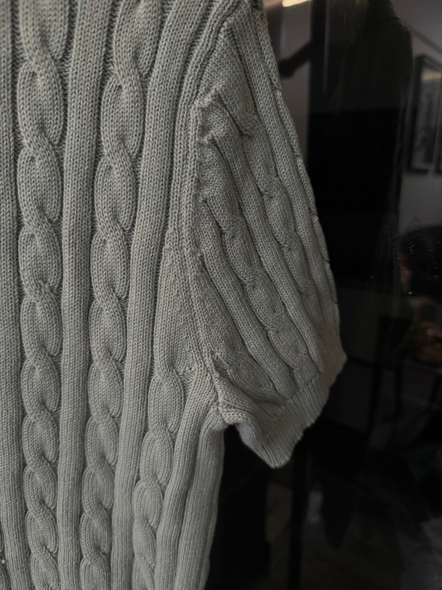 Gray cable-knit polo sweater side view with textured cable pattern