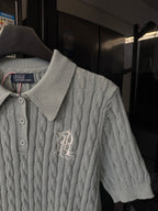 Gray cable-knit polo sweater with ribbed collar and embroidered chest logo detail