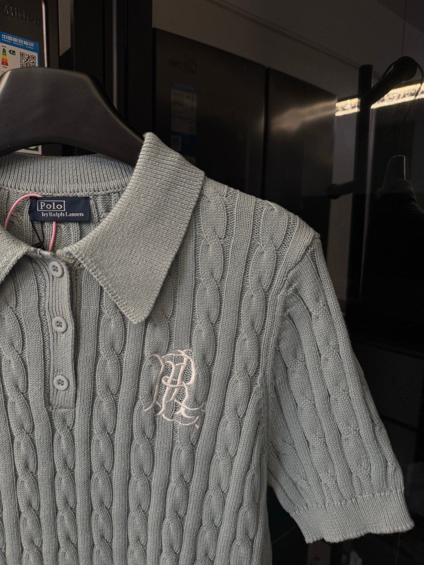 Gray cable-knit polo sweater with ribbed collar and embroidered chest logo detail