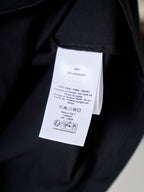 Dior T-shirt care label tag on black fabric