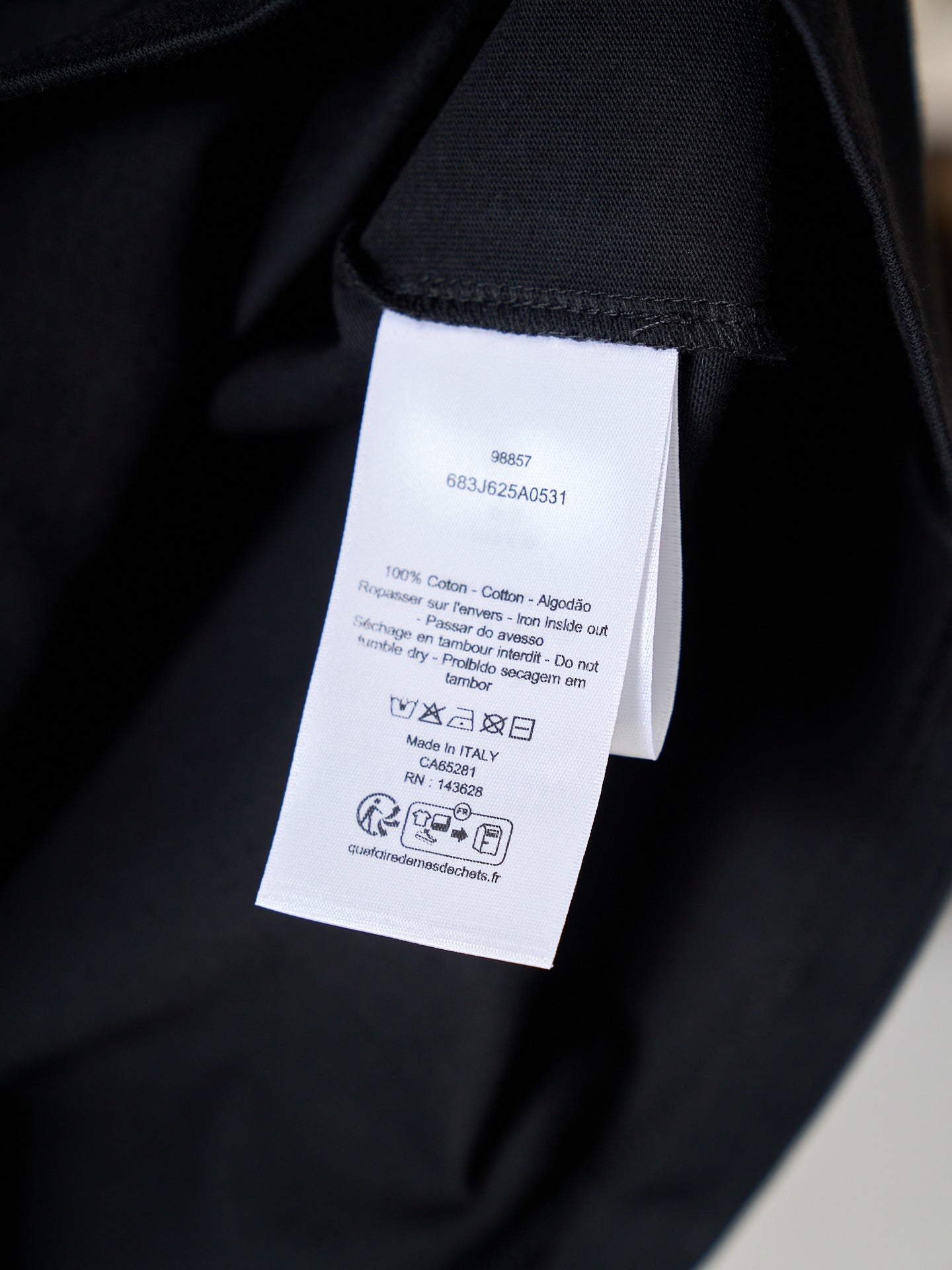 Dior T-shirt care label tag on black fabric