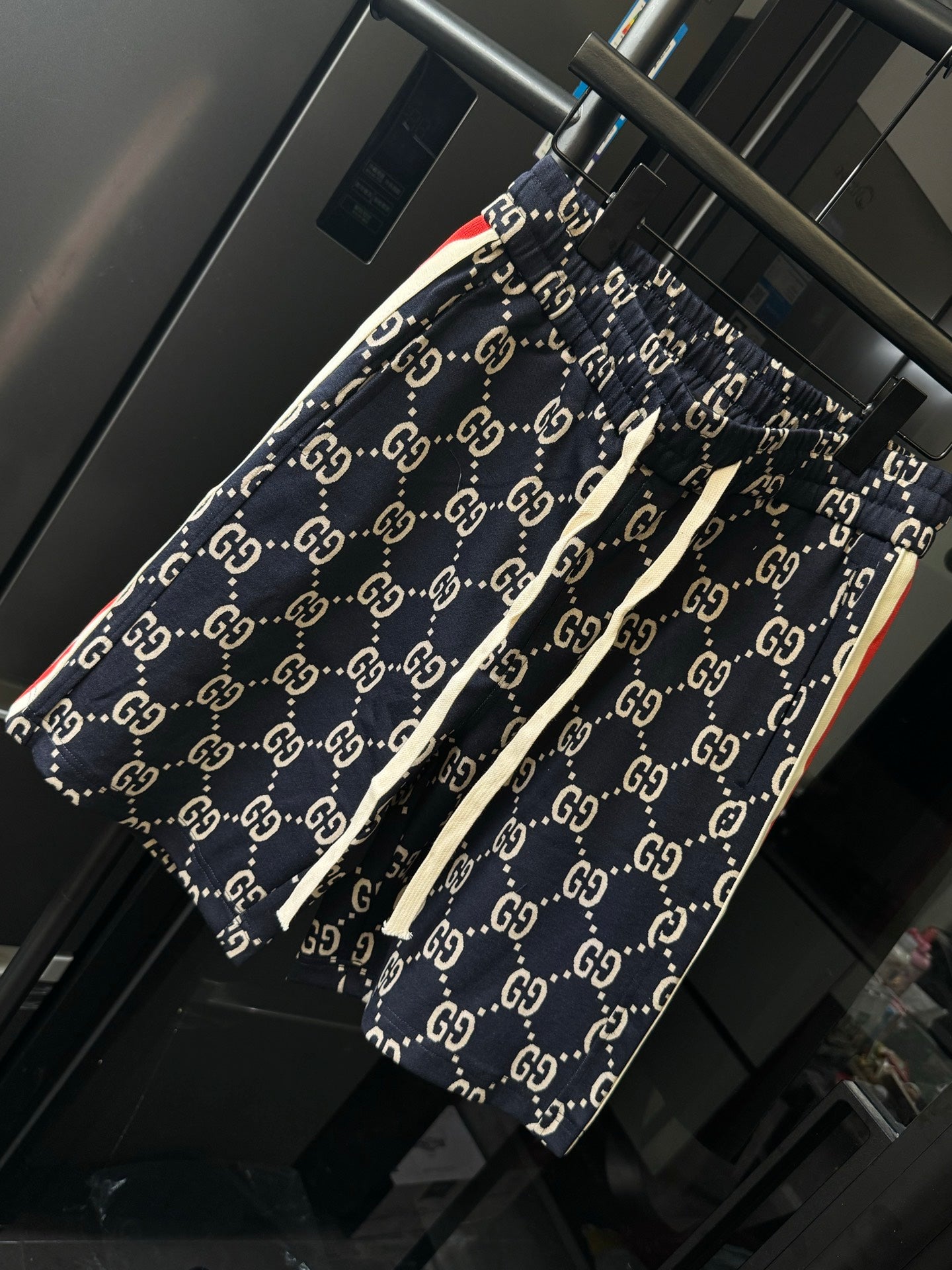 Gucci pants with navy GG monogram print and side seam detail, angled view
