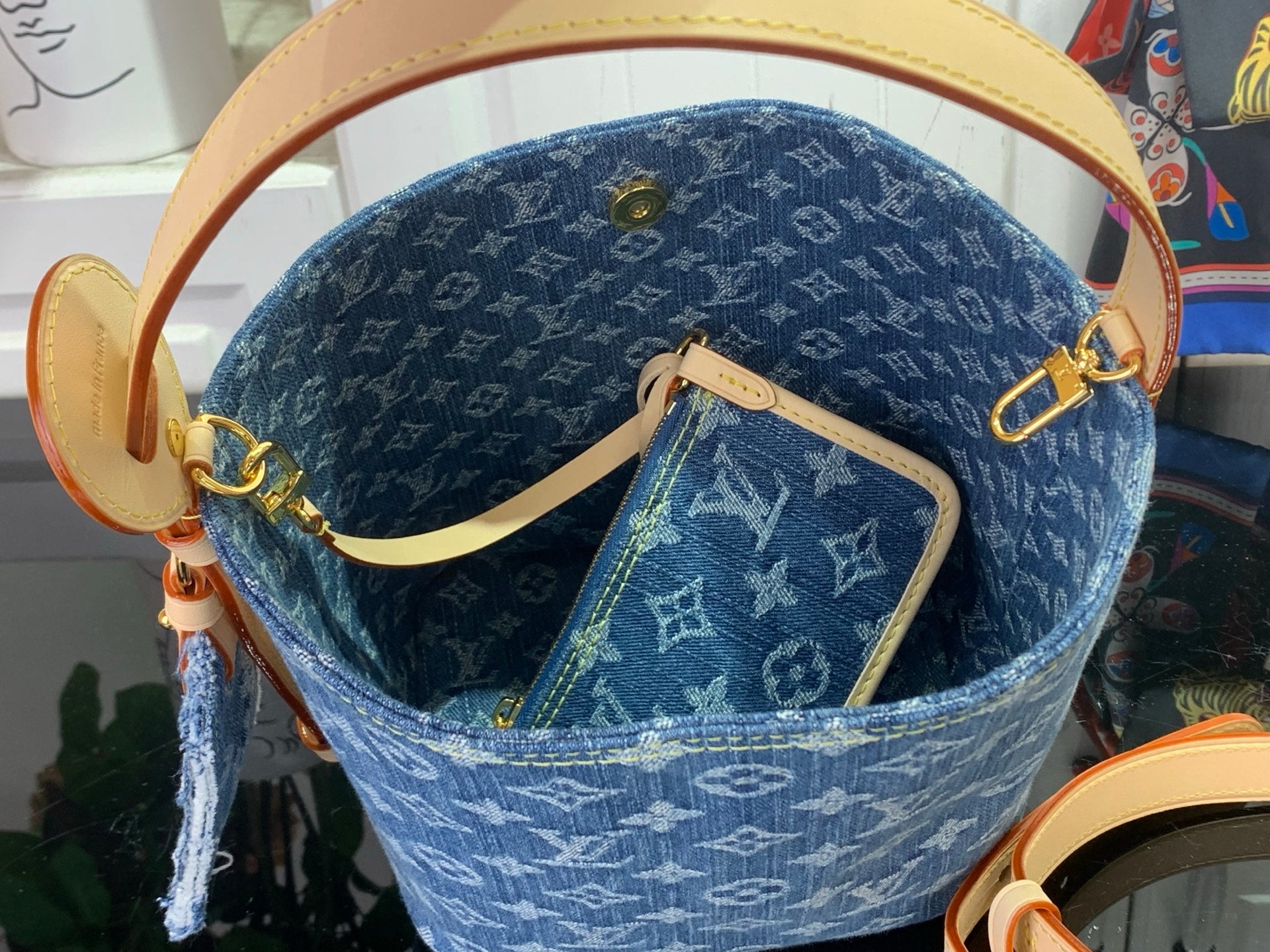 Louis Vuitton monogram tote bag with tan handles, gold hardware, and front pouch