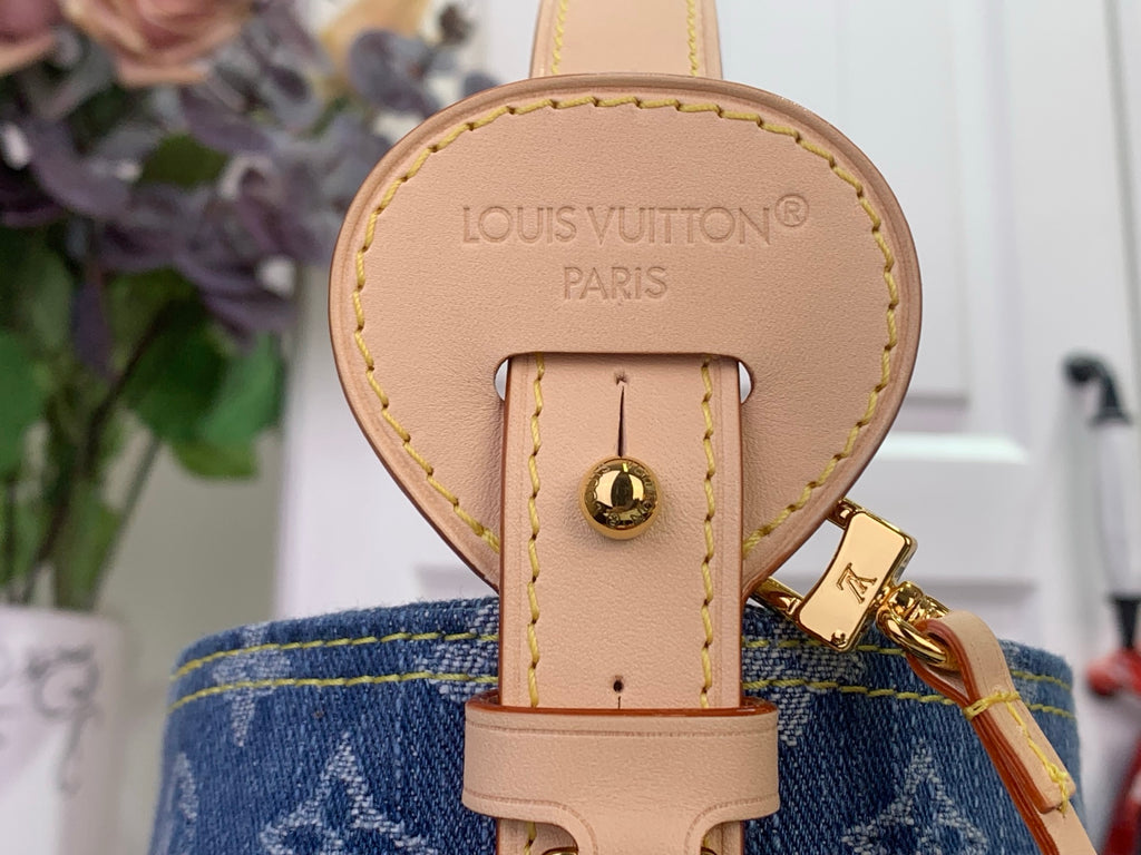 Louis Vuitton key pouch with tan leather tag and gold clasp on blue monogram