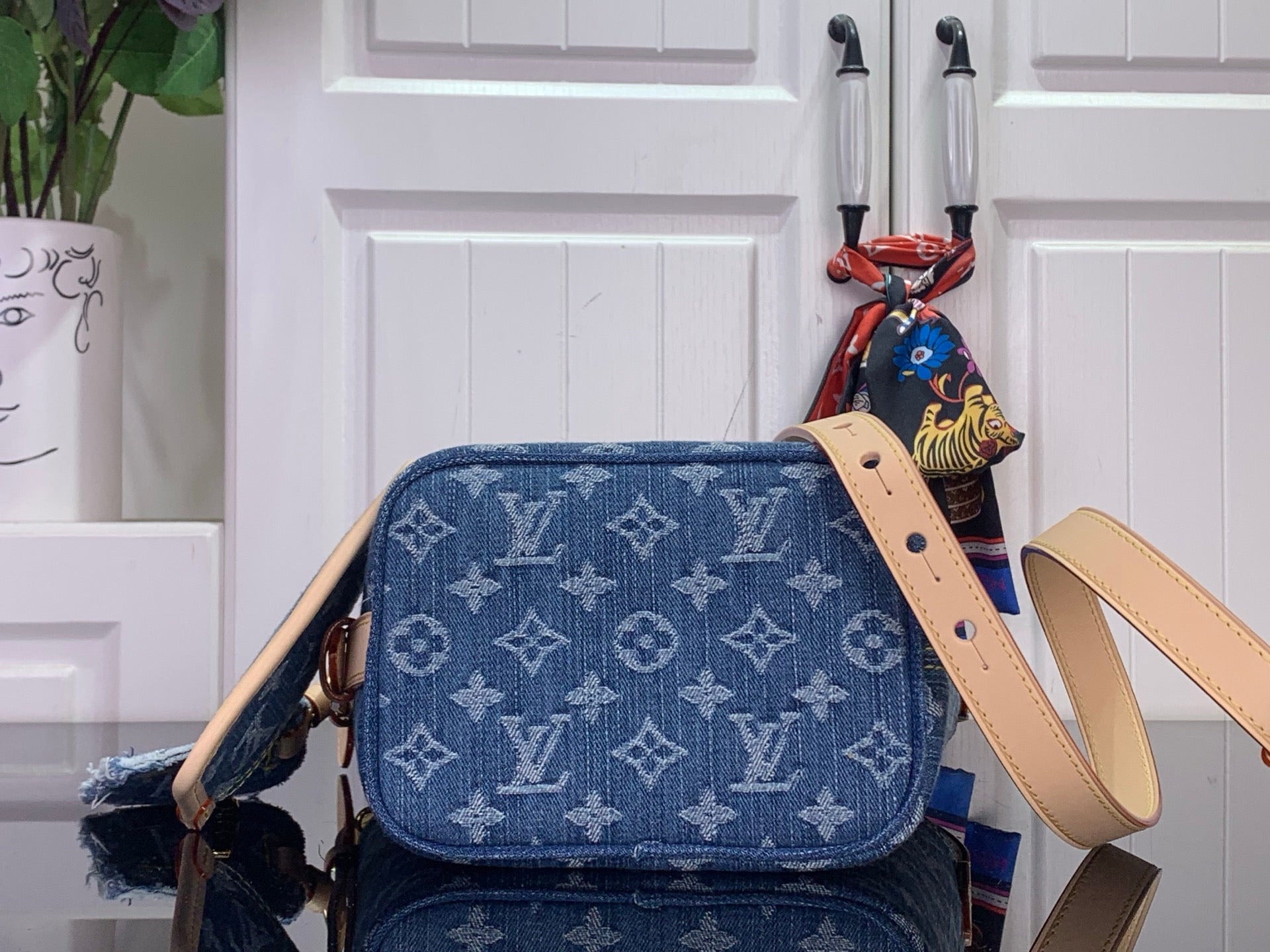 Louis Vuitton monogram shoulder bag with tan strap and front flap pocket
