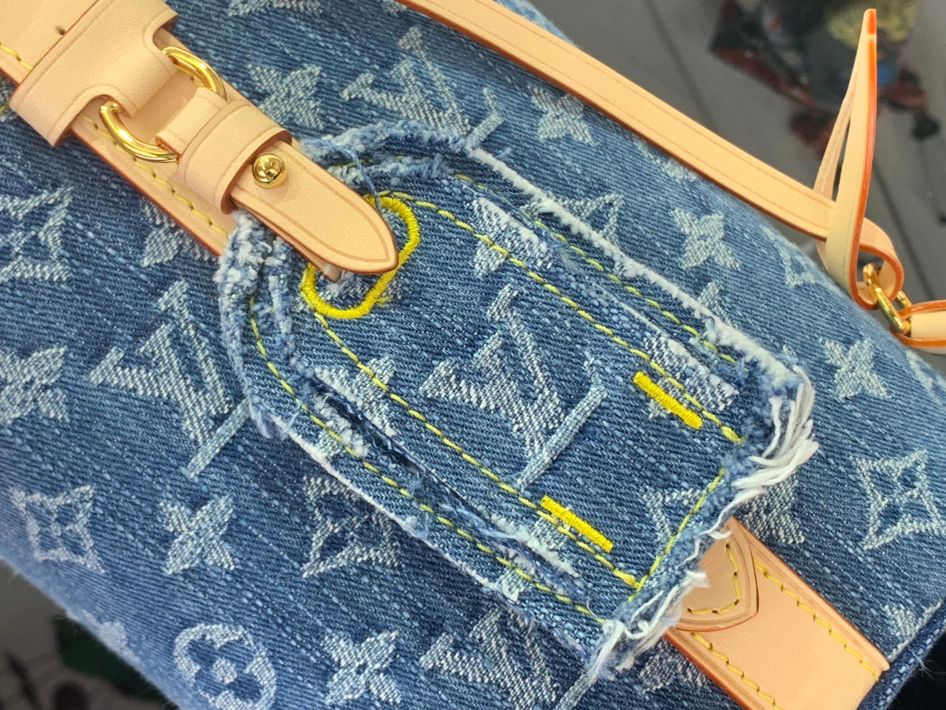Blue monogram denim bag with leather strap and gold buckle