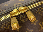 Louis Vuitton monogram bag zipper with gold-tone pull and metal slider hardware.