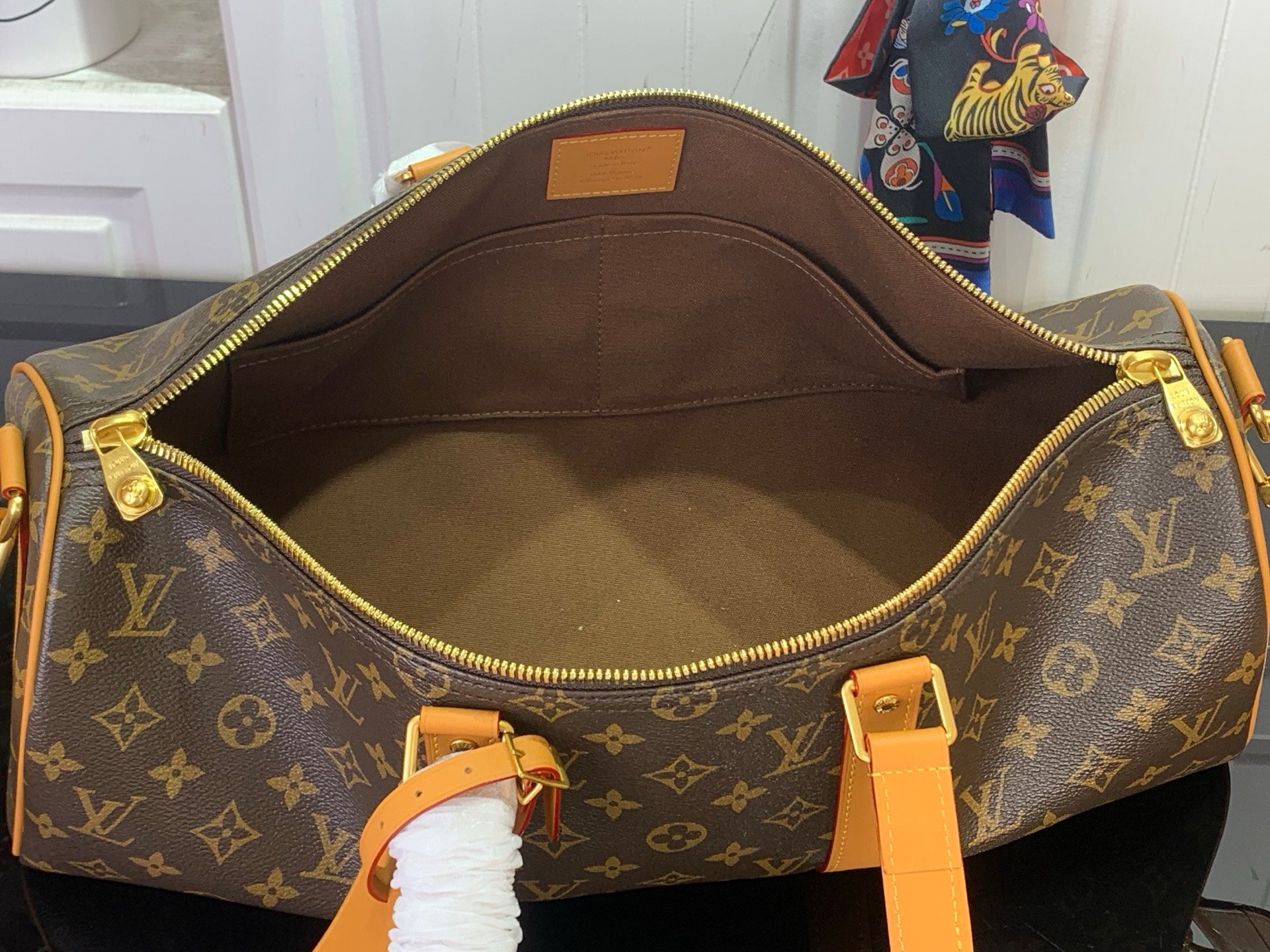 Louis Vuitton monogram duffel bag open interior with zip closure and tan trim.
