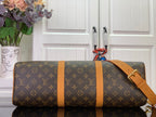 Louis Vuitton monogram duffel bag with tan leather straps and adjustable shoulder strap.