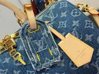 Blue monogram denim bag detail with tan strap, stitched trim, and label