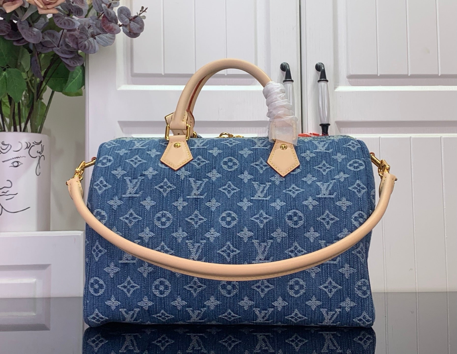 Louis Vuitton blue monogram handbag with tan top handles and gold clasp hardware