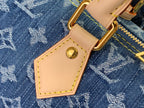 Louis Vuitton handbag strap detail with tan leather patch and gold D-ring hardware