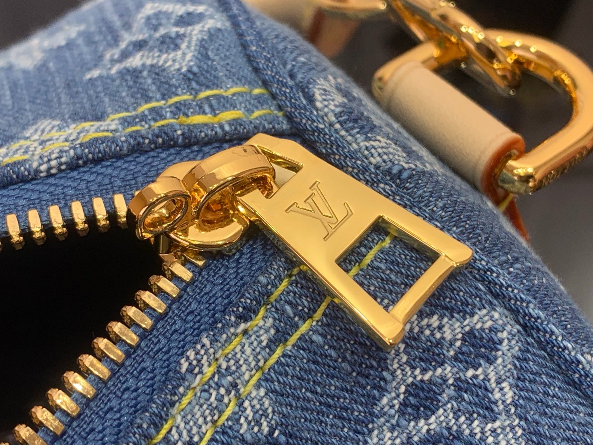 Louis Vuitton metal hardware charm with gold clasp on denim zipper