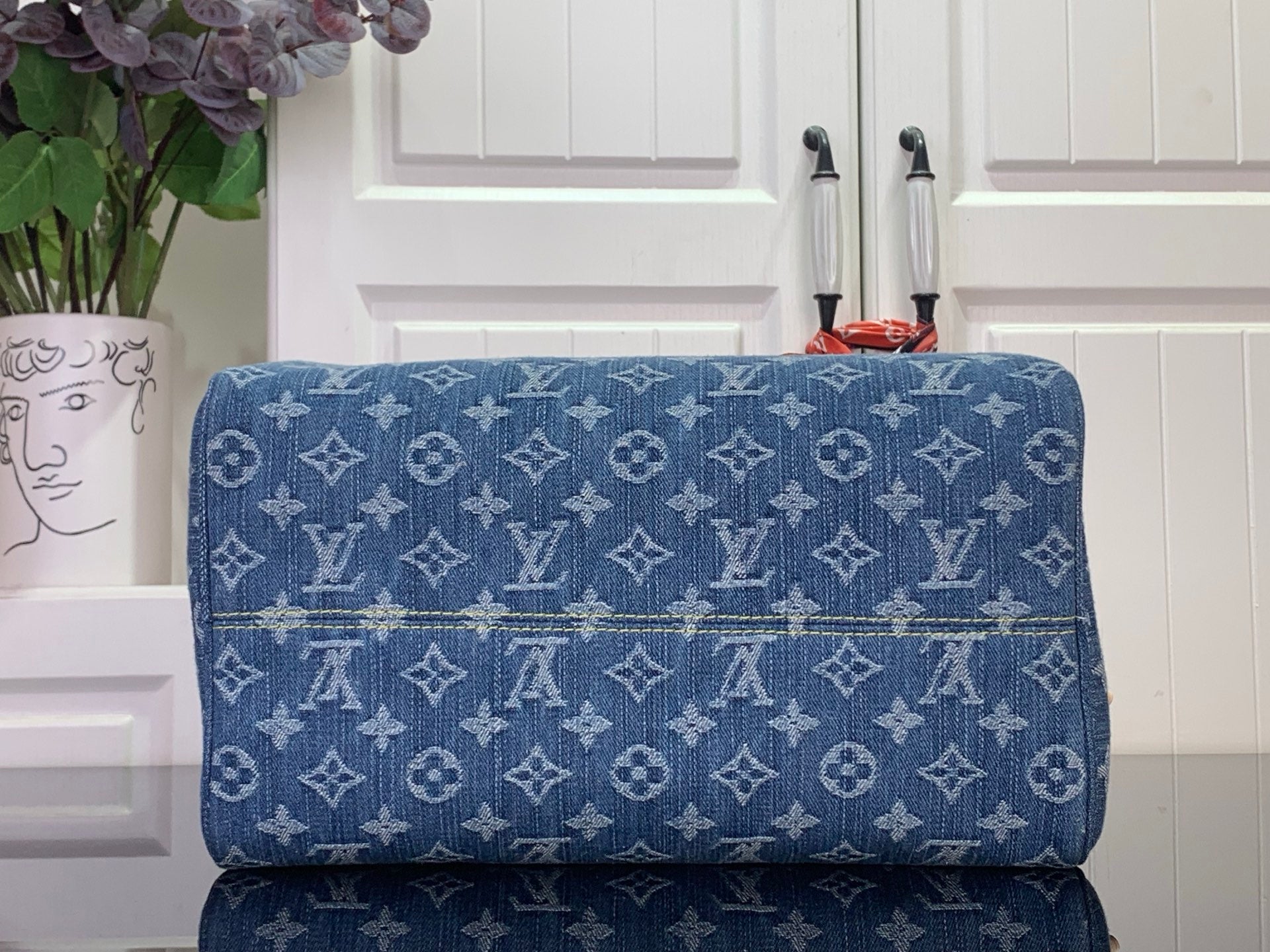 Louis Vuitton blue monogram handbag back view with stitched texture and gold hardware