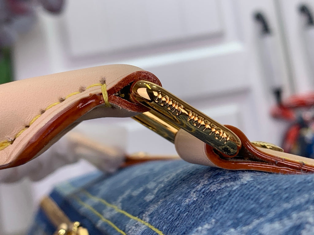 Louis Vuitton handbag leather trim and gold-tone clasp hardware with engraved accents