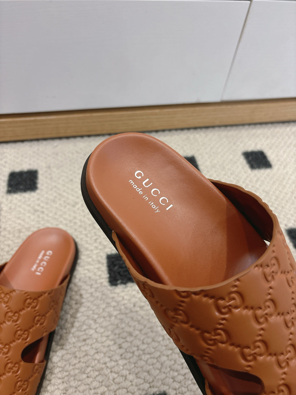 Gucci tan monogram slide sandal close-up with logo footbed and open toe