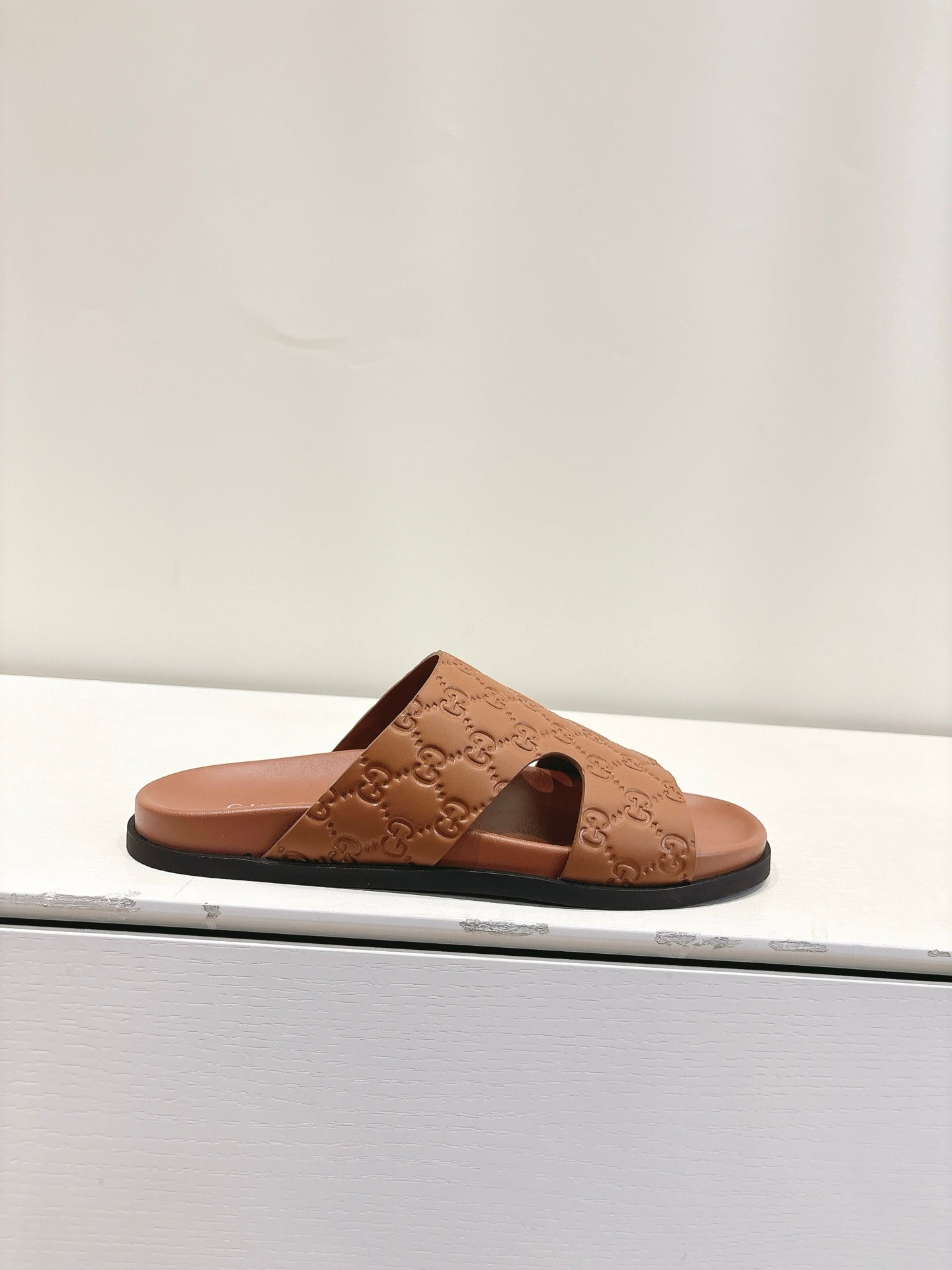 Gucci tan monogram slide sandals with open toe and wide strap, flat sole