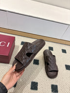 Gucci dark brown embossed slide sandals with open toe and logo strap, one held