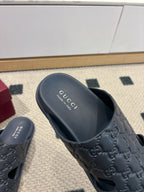 Gucci dark blue slide sandal with GG embossed upper and branded footbed