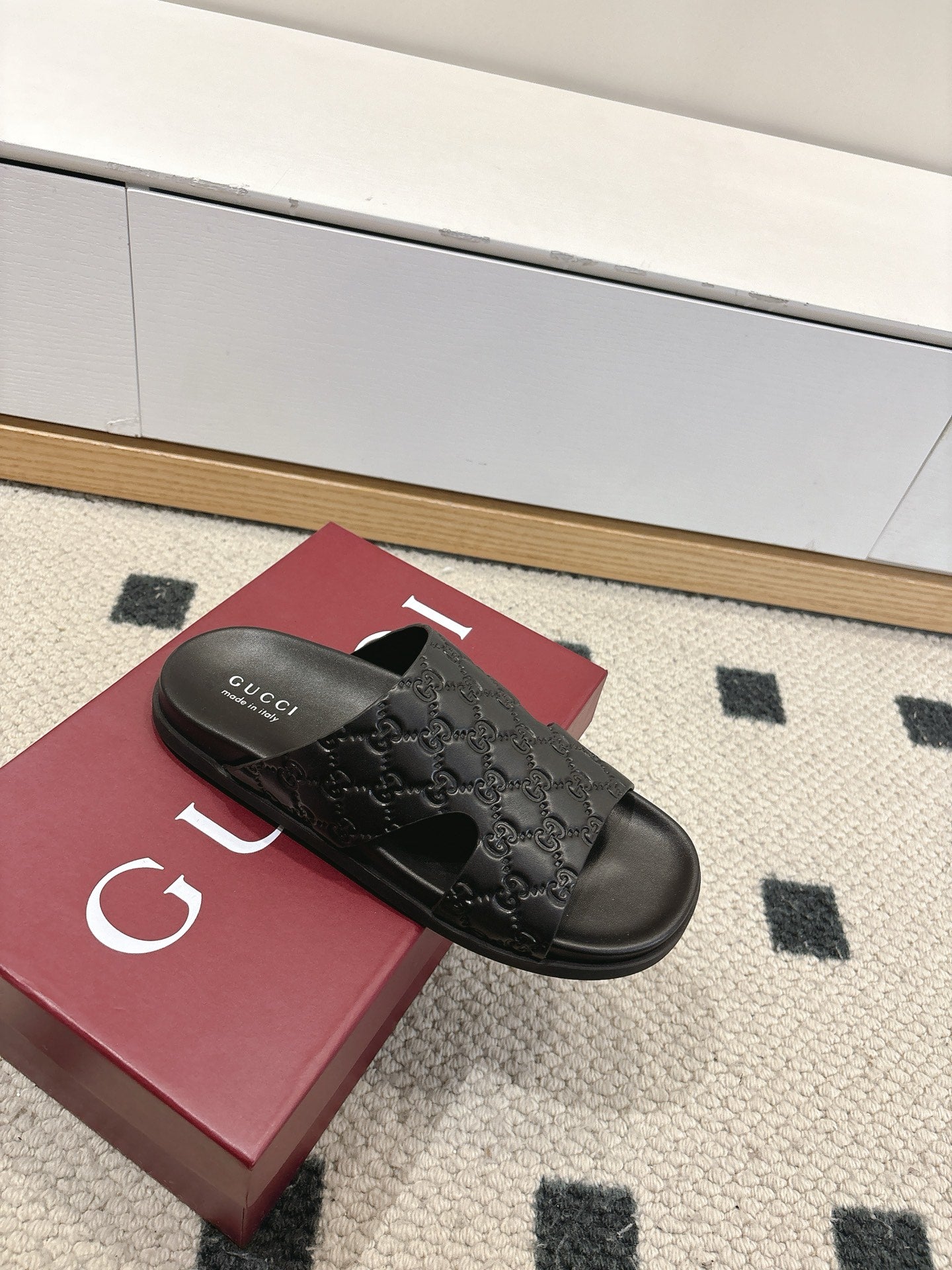 Gucci black slide sandals with embossed monogram strap and black footbed