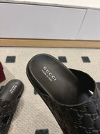 Gucci black slide sandal footbed with Gucci logo text