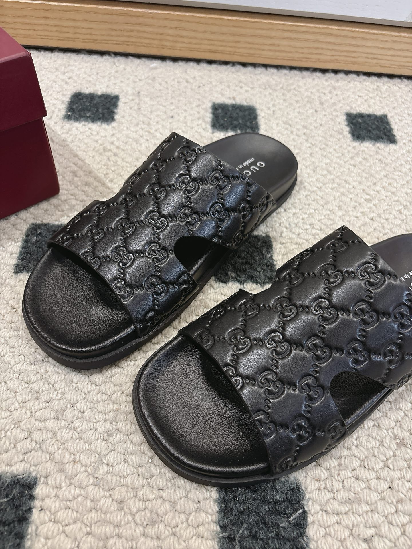 Gucci black slide sandals with embossed monogram straps and open toe