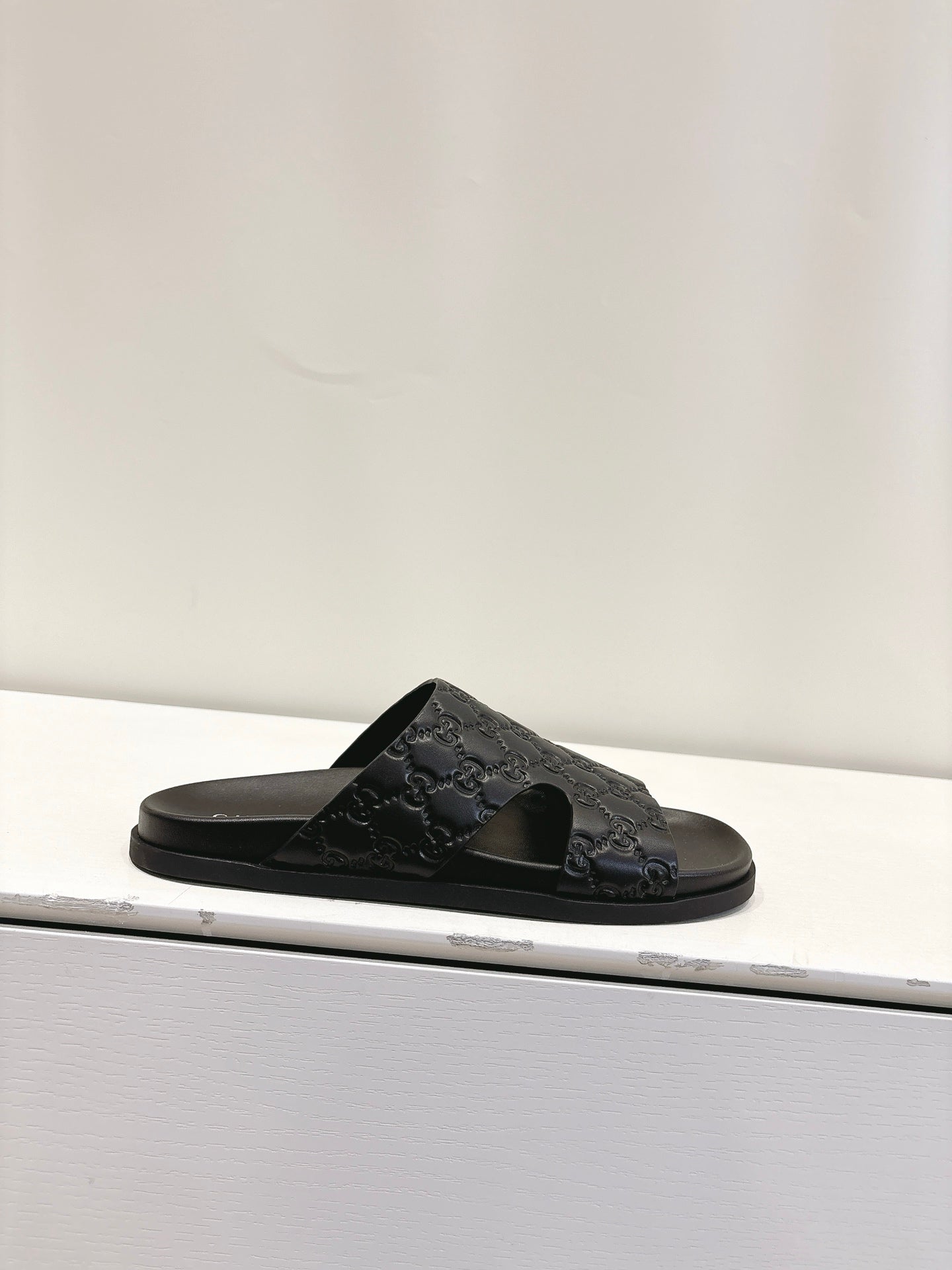 Gucci black slide sandal with embossed monogram strap