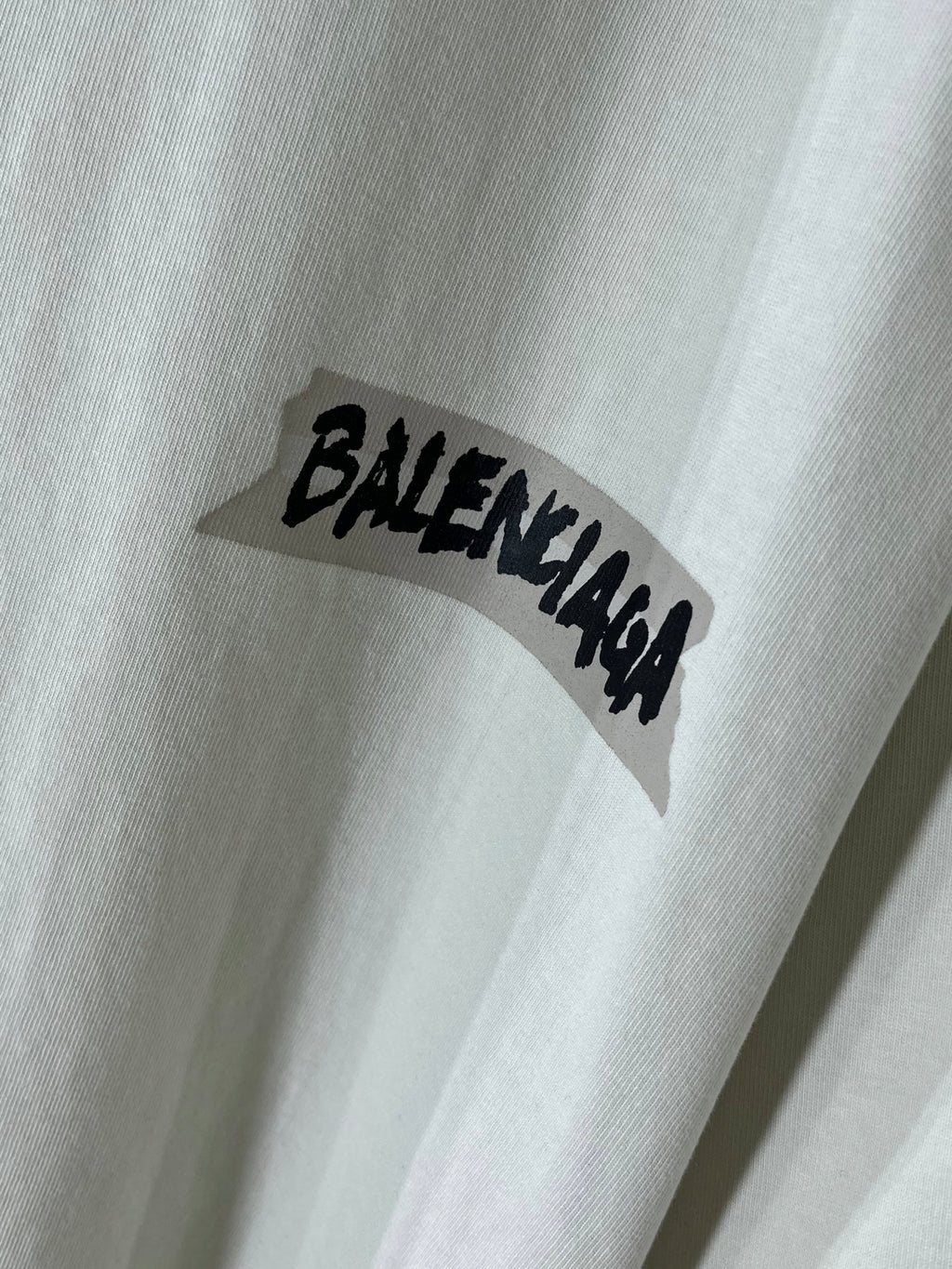 White Balenciaga T-shirt sleeve with black BALENCIAGA logo text