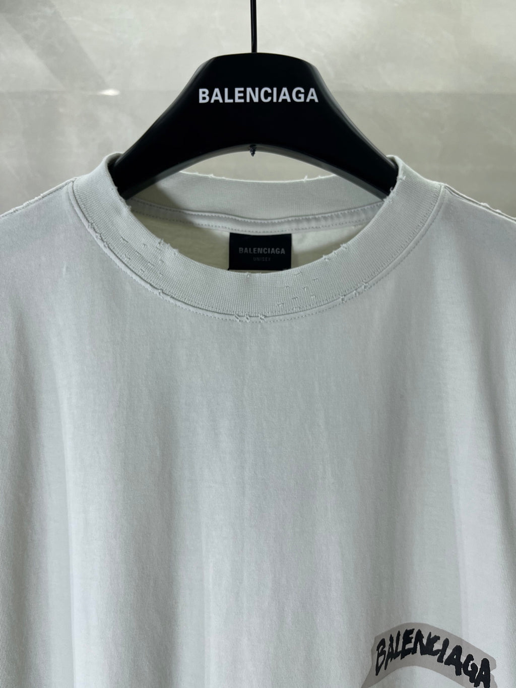 White Balenciaga T-shirt close-up: crew neck with logo print