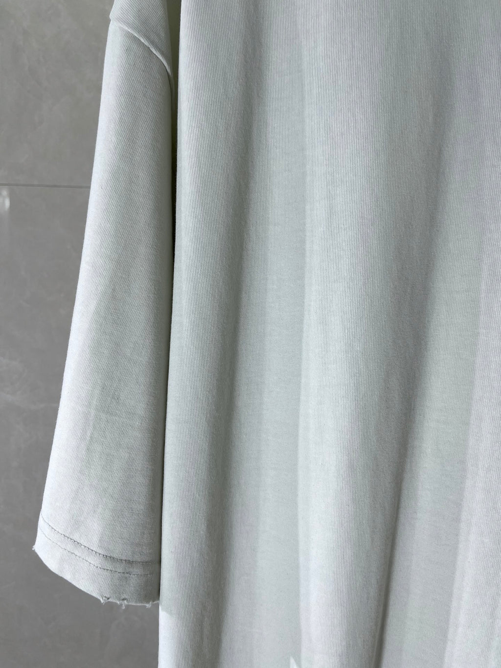 White Balenciaga T-shirt showing sleeve and curved hem, plain body