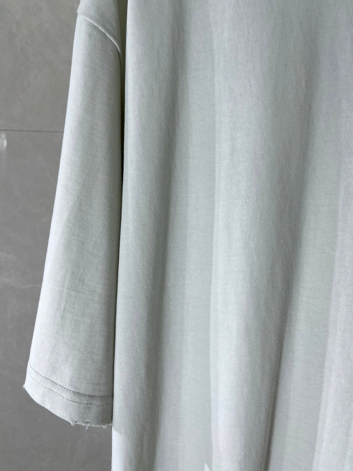 White Balenciaga T-shirt showing sleeve and curved hem, plain body